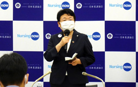 会見で挨拶をする福井会長の画像